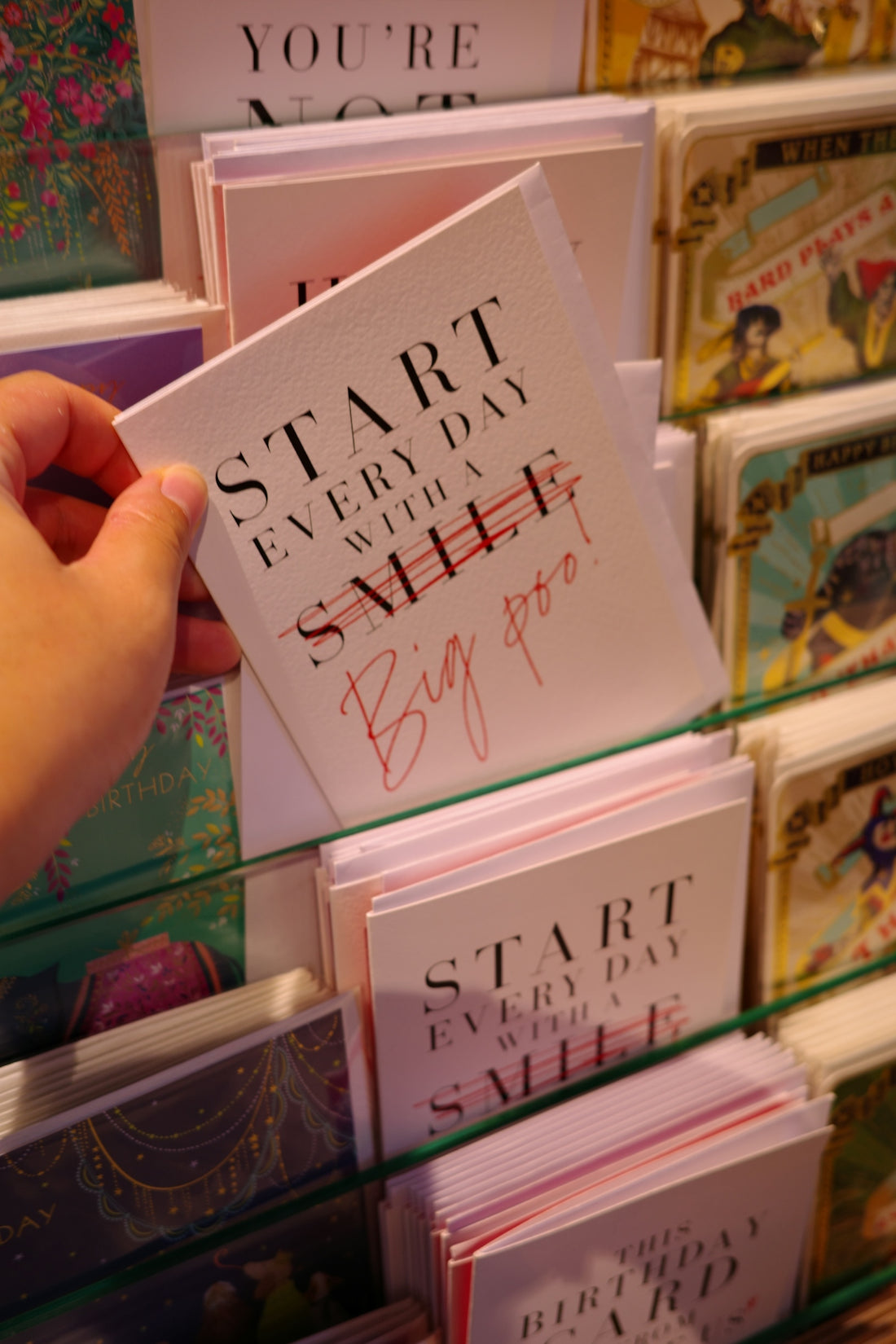 Hand holding a greeting card with text.